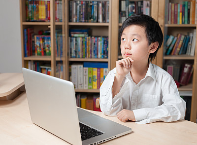 亚洲男孩坐在笔记本电脑前图片下载