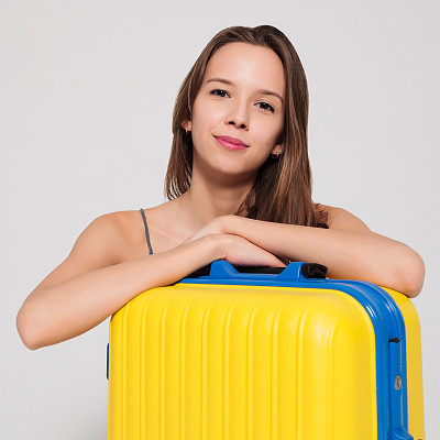 带着黄色手提箱的漂亮女孩喜欢旅行图片下载