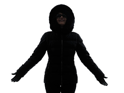 女人冬大衣双臂伸出幸福的剪影图片下载