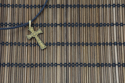 金十字架在柳条垫子上图片下载