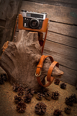 棕色皮带和木制背景的复古相机图片下载