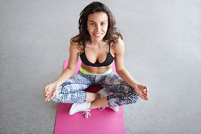 年轻女子在练习莲花体位的瑜伽图片下载