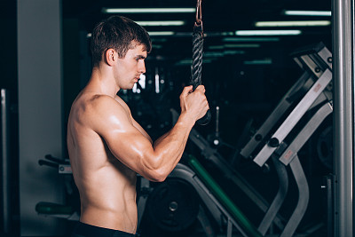 肌肉男在健身房锻炼三头肌图片下载