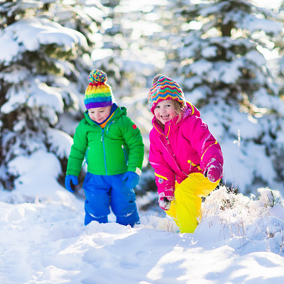 圣诞节期间，孩子们在下雪的冬季公园玩耍图片下载