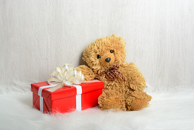 白色地毯上放着泰迪熊和礼物图片下载