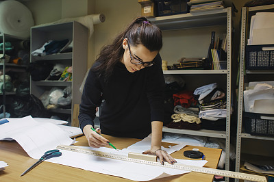 女时装设计师在真实的车间室内工作图片下载