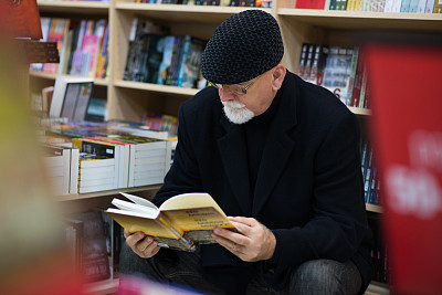 人们正在图书馆的书架上挑选书图片下载