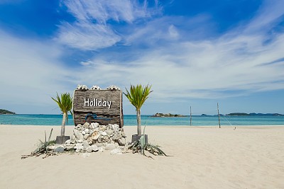 海滩上木制的标志上写着节日的文字图片下载