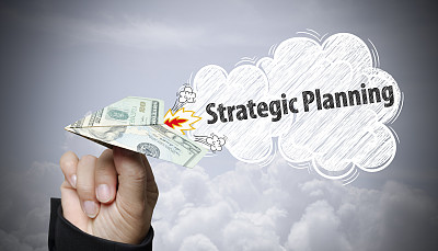 商人手握美元飞机与战略规划图片下载