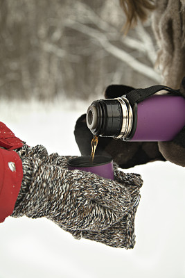 雪域森林里热水瓶里的热茶。冬天图片下载