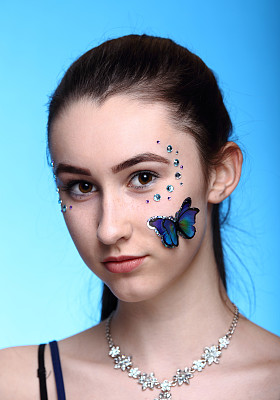 漂亮的少年与装饰的脸。图片下载