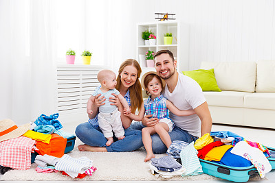 幸福的家庭妈妈，爸爸和两个孩子收拾了行李箱图片下载