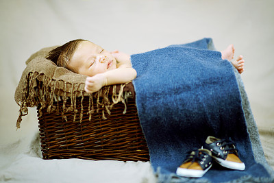 刚出生的男婴睡在篮子里图片下载
