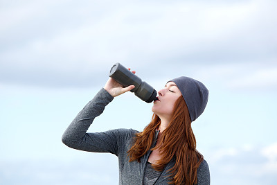 健身女性在户外喝瓶装水图片下载