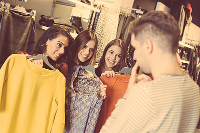 男人帮助三个女人挑选新衣服图片下载