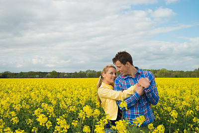 油菜地里一对幸福的情侣图片下载