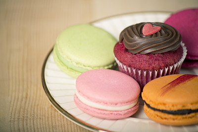 被杏仁饼干包围的心形纸杯蛋糕图片下载