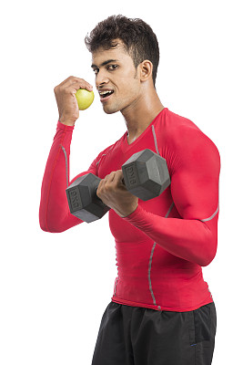健身的年轻人拿着哑铃，吃着青苹果图片下载