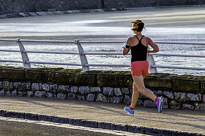 女人，慢跑，晨跑在海边，彩色影像。图片下载