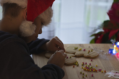 戴着圣诞帽的男孩做圣诞饼干图片下载