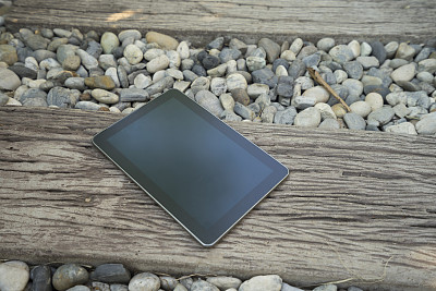 在石头和木制人行道上的数字平板设备图片下载