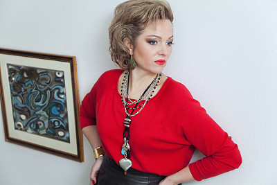 漂亮的金发女人靠在墙上摆着照片图片下载