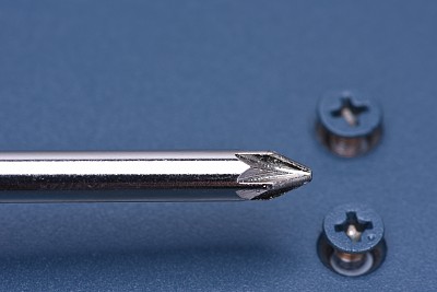 金属表面的螺丝刀和螺丝图片下载