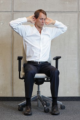 在椅子上锻炼的商人——瑜伽办公室图片下载