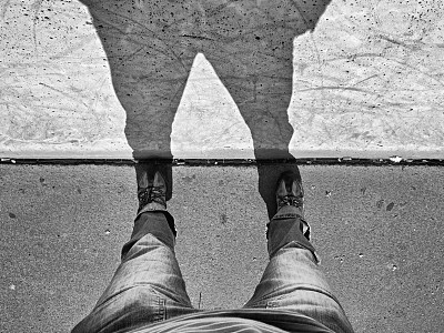 男人的长腿站在街的墙上有影子图片下载