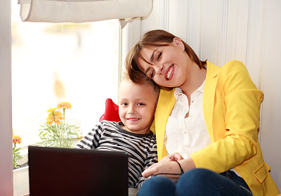 快乐的母子在家里看笔记本电脑图片下载