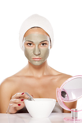 年轻美丽的女人摆着一张面具图片下载