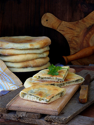 木质背景上是一堆带有奶酪和春天蔬菜的格鲁吉亚派。空间的文本图片下载