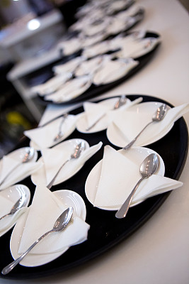 大量的白色盘子、碟子、勺子和纸巾图片下载