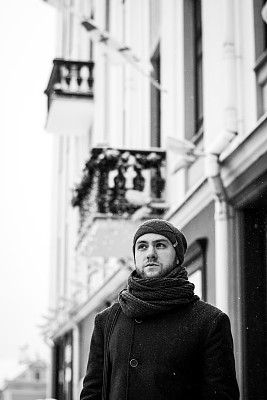 户外肖像英俊的男子在灰色大衣。时尚照片。美丽冬天下雪的风格。黑色和白色图片下载