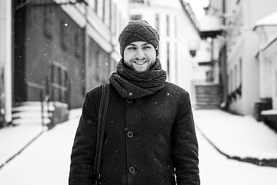 户外肖像英俊的男子在灰色大衣。时尚照片。美丽冬天下雪的风格。黑色和白色图片下载