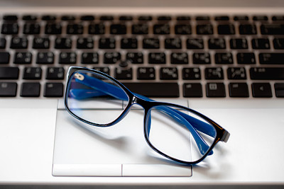 笔记本电脑上商人眼镜的特写。图片下载