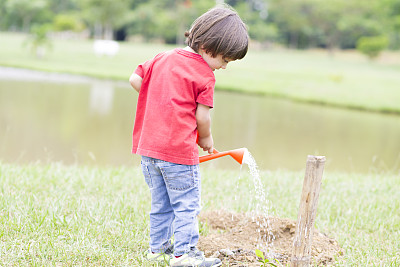 小男孩在户外浇水图片下载