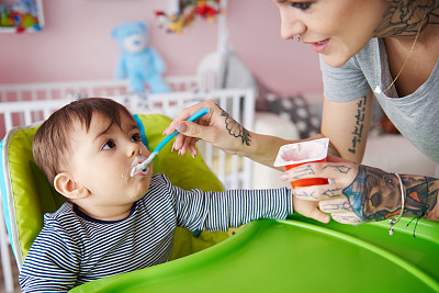 小男孩在他的高椅子上吃东西图片下载