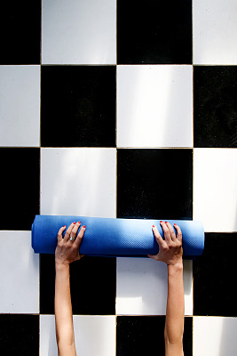 瑜伽课结束后，一个女人在滚动她的垫子图片下载