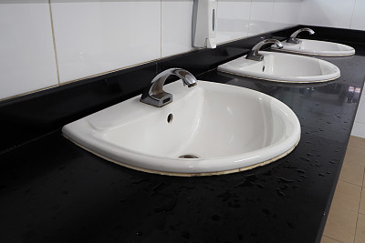 公共卫生间的肥皂液盒和白色洗涤槽。图片下载