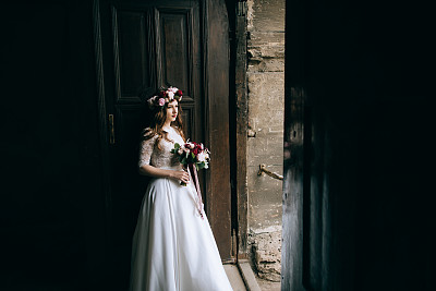 一个美丽的新娘在一个花圈婚礼上的肖像。乡村风格图片下载