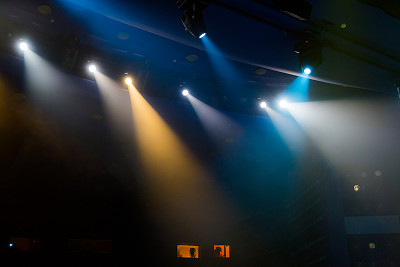 在演出期间，聚光灯发出的蓝光透过剧院里的烟雾。照明设备图片下载