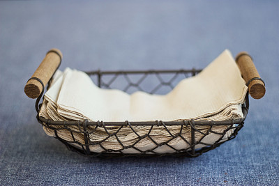 金属篮子里的薄纸巾放在蓝色的布桌上图片下载