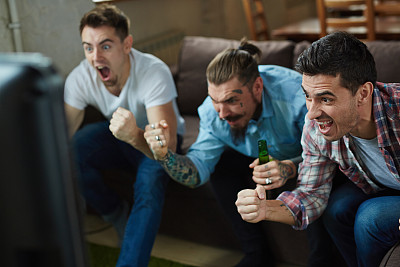 激动的体育迷为电视喝彩素材图片