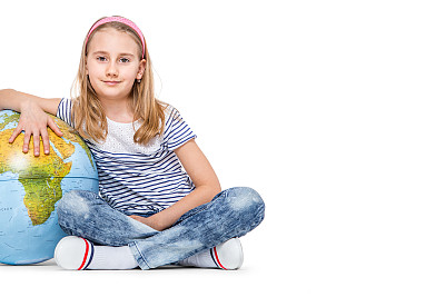 带着地球仪的可爱小学生女孩。学校教育的概念图片下载