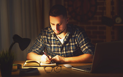 人们晚上在黑暗中在家里用电脑工作图片下载