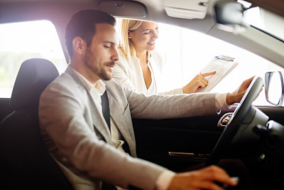 销售人员在汽车经销商销售汽车图片下载