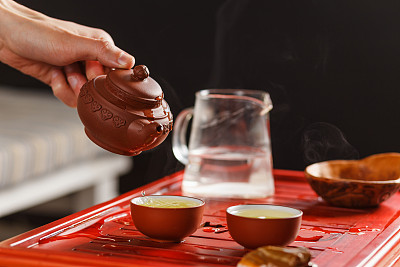 茶道：女人在茶碗里倒茶素材图片