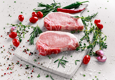 生猪里脊排骨放在砧板上，配上香草，迷迭香，百里香，辣椒，盐，胡椒。图片下载