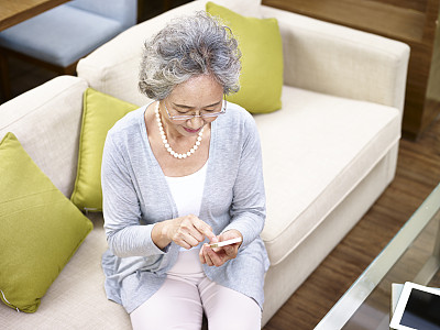在家里使用手机的亚洲资深女性图片下载